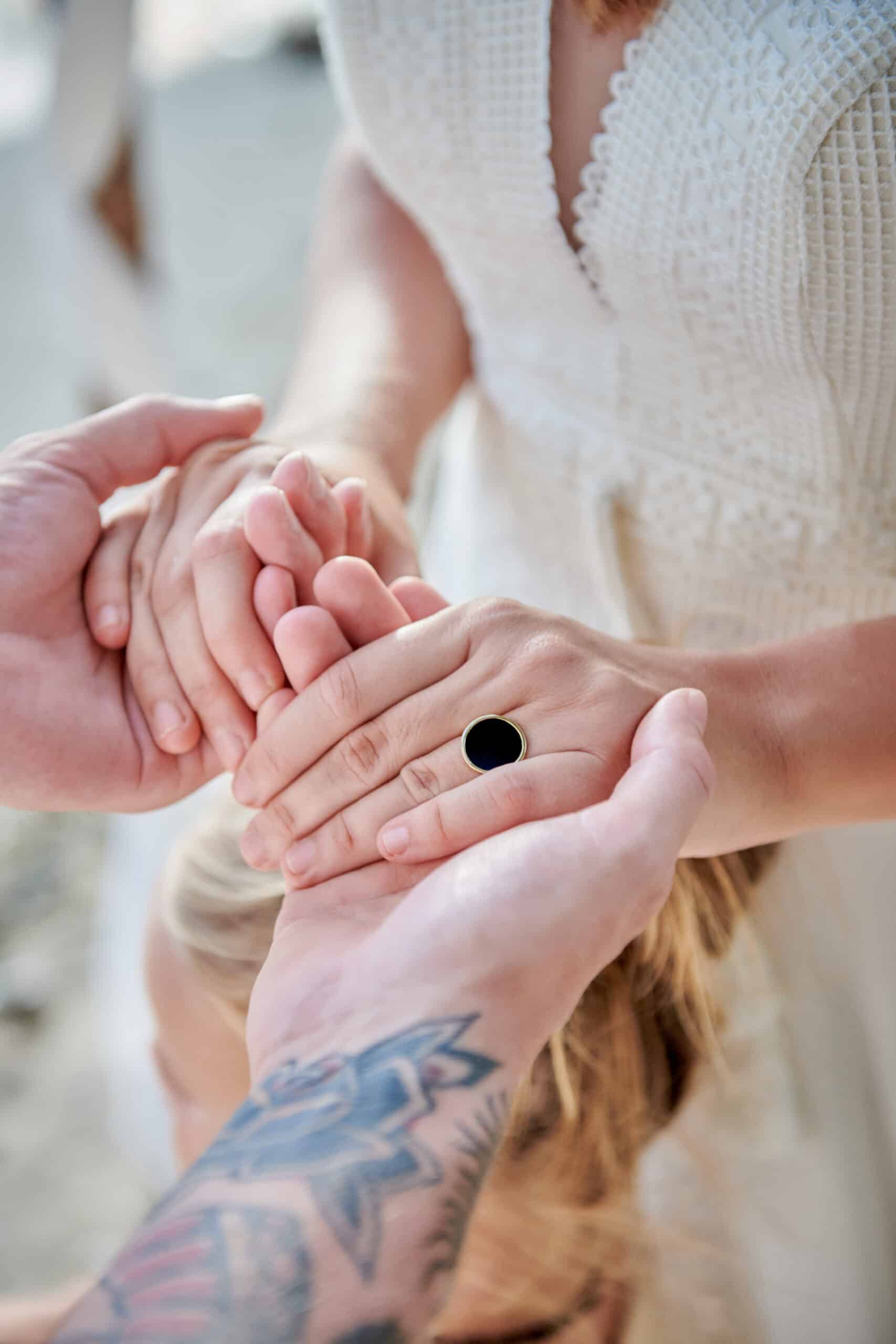 beach wedding ceremony holding hands