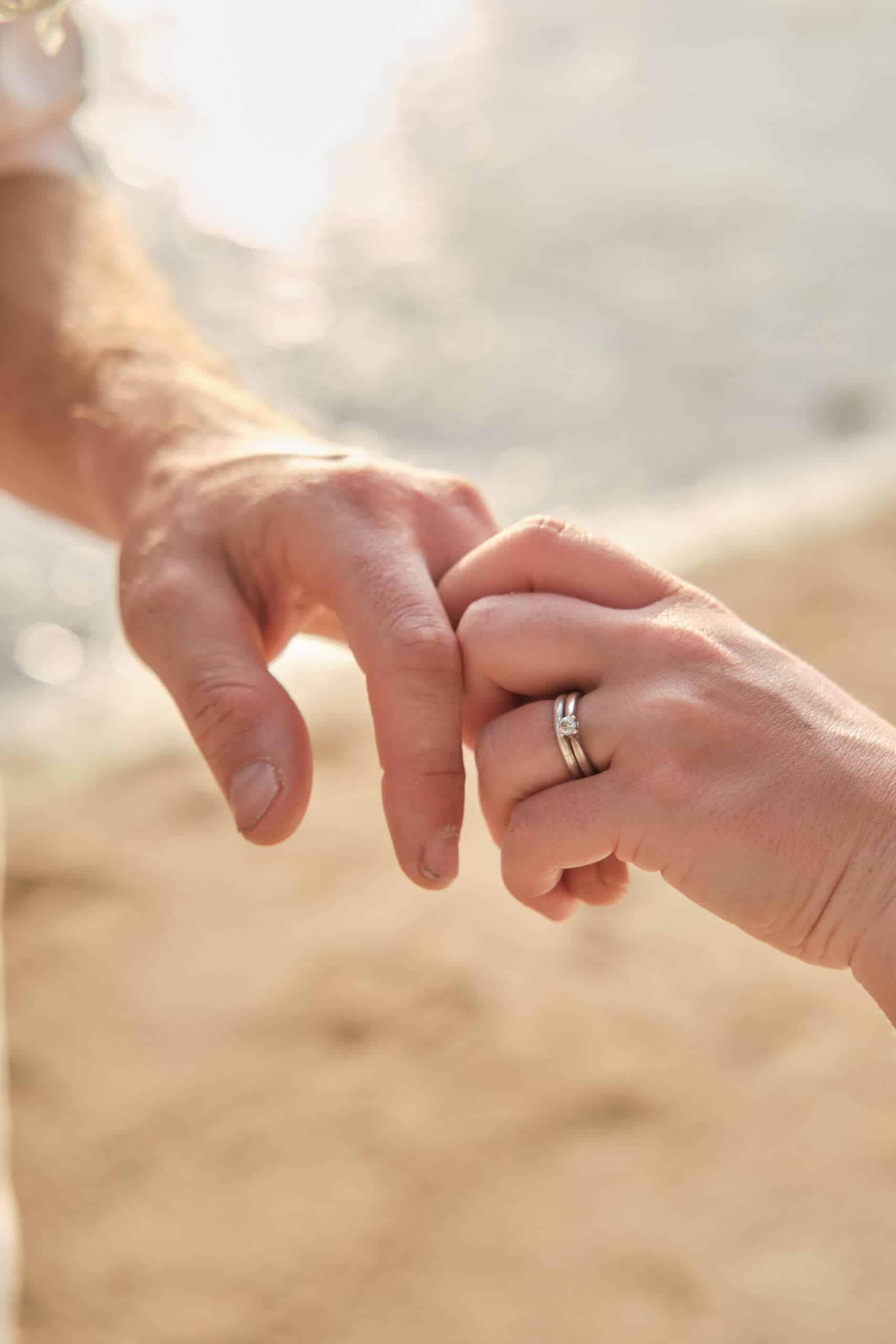beach wedding couple holding hands