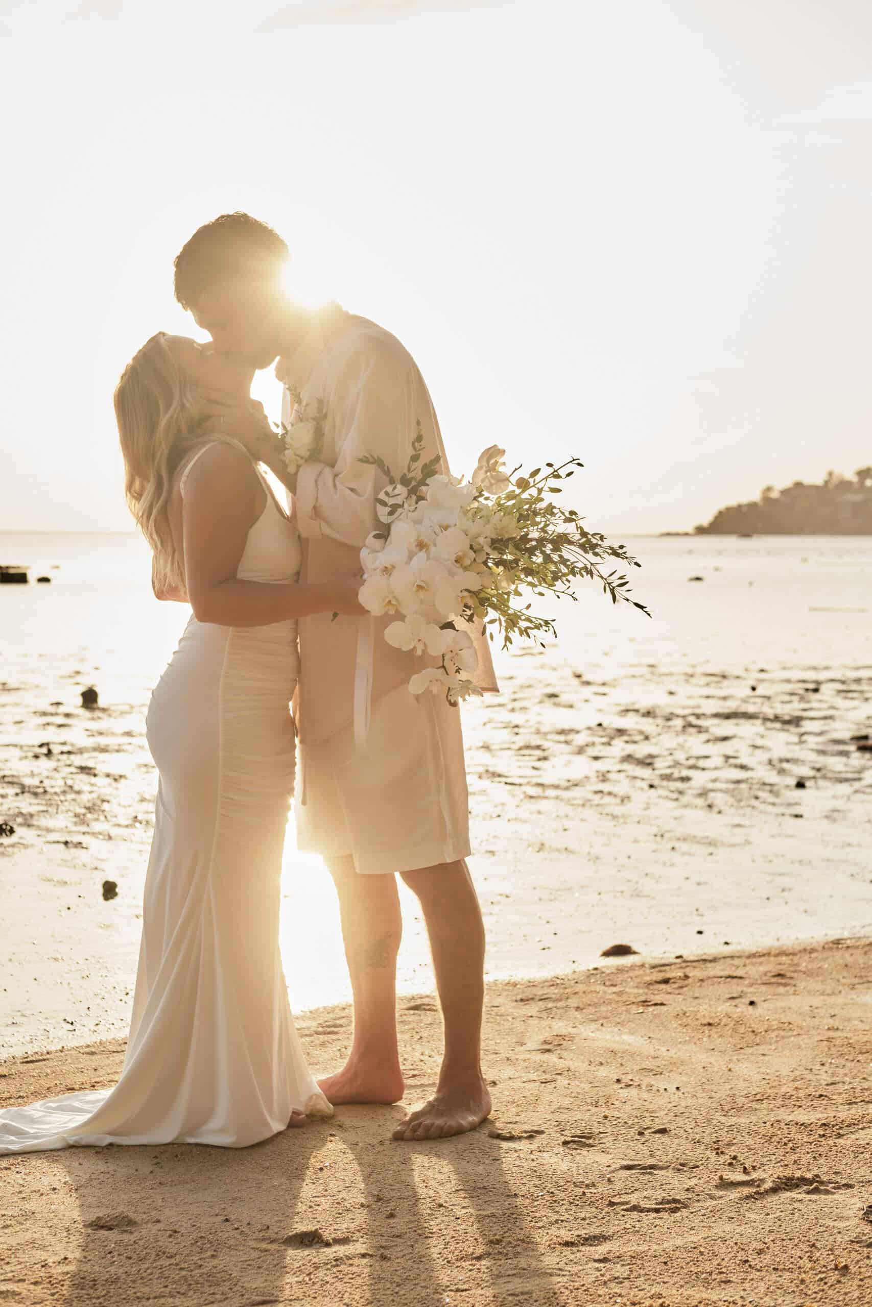 beach wedding couple shooting flowers