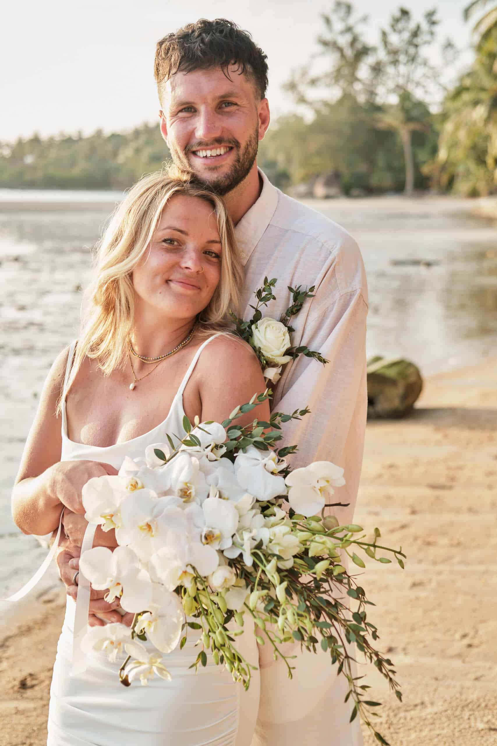 beach wedding couple shooting flowers