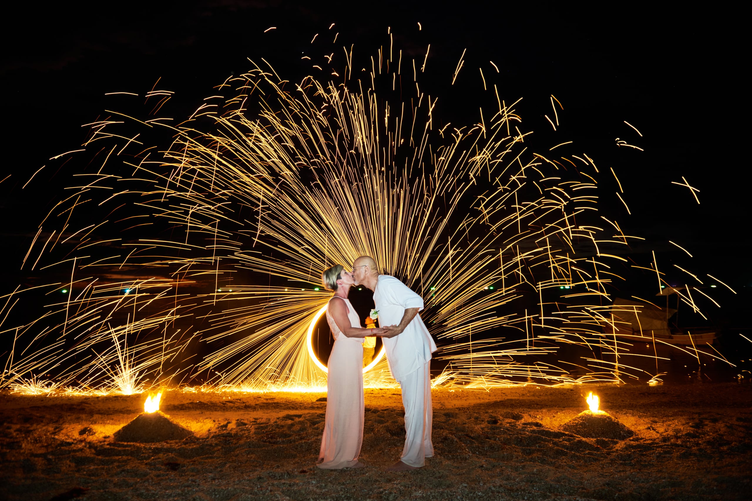 beach wedding fire show at night couple